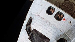 Photo of Space Shuttle Atlantis preparing to dock with the Russian Mir space station on November 14, 1995, during the STS-74 mission. NASA astronauts are visible crowding the windows.